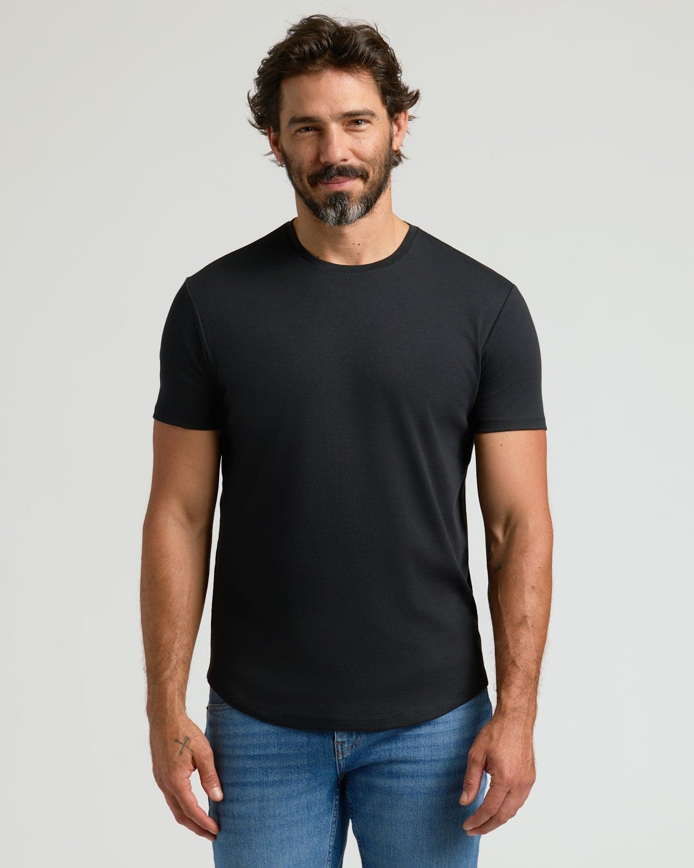 White man wearing a black True Classic Pima crew with a curved hem